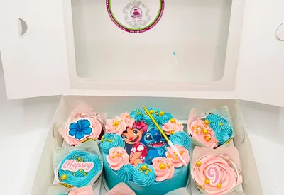 Gift box of Lilo and Stitch themed cupcakes with a mini heart cake in the centre