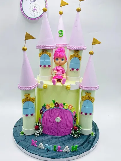 Pastel princess castle novelty cake with pink turrets and a doll topper