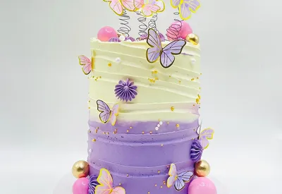 Tall purple ombre buttercream cake with iridescent butterflies and gold, pink and white spheres